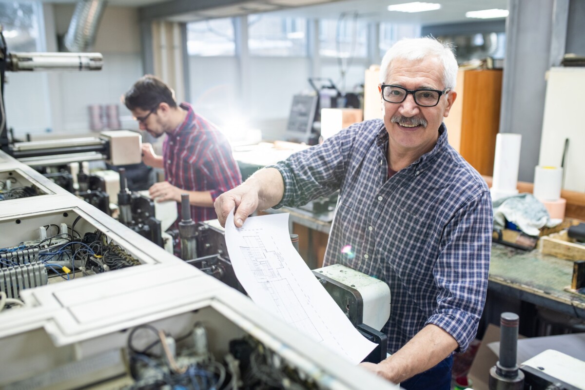 man-getting-printed-paper-out-of-printing-press.jpg